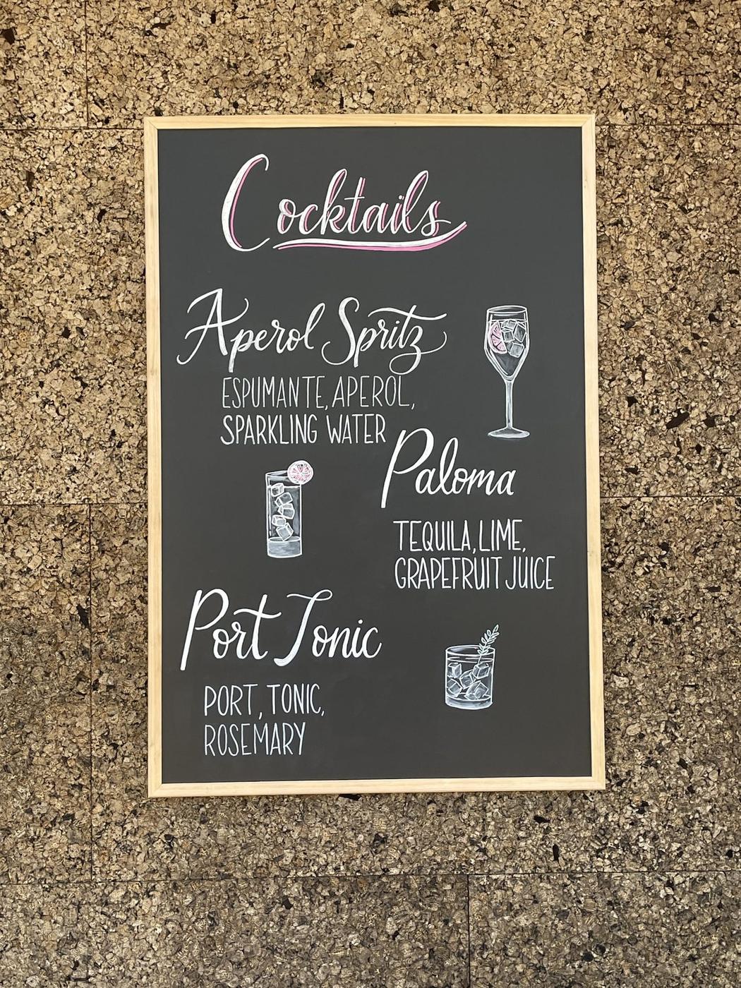 Illustrated cocktail menu chalkboard with hand-lettered drink names
